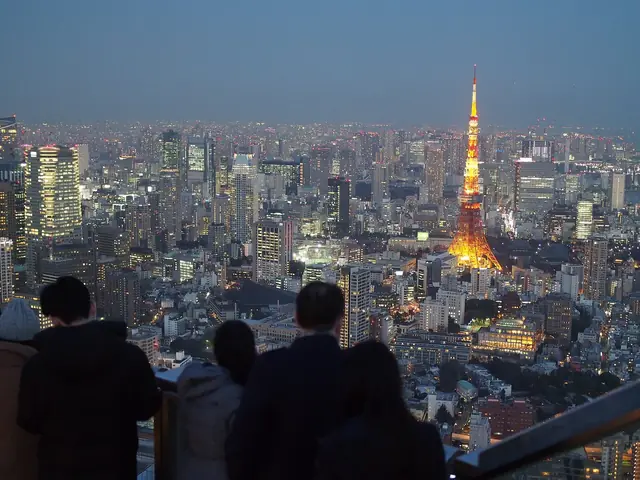 六本木ヒルズ森タワー屋上から夕暮れの東京タワーを眺める人々