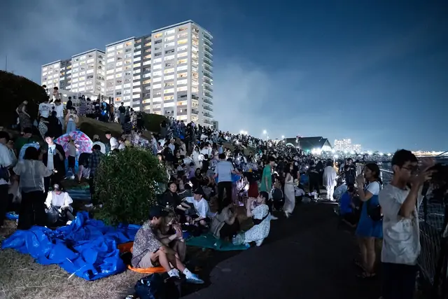シートを広げて隅田川花火大会を待つ河川敷の見物客