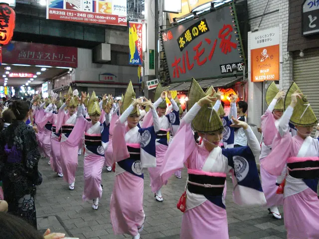 ピンクの浴衣に編み笠姿で高円寺の通りを踊り進む阿波踊りの連