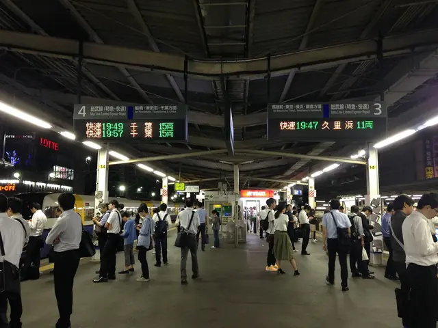 夜のJR錦糸町駅のホームで電車を待つ乗客