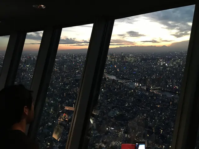 夕暮れの東京スカイツリー展望デッキの大きな窓と眼下の街