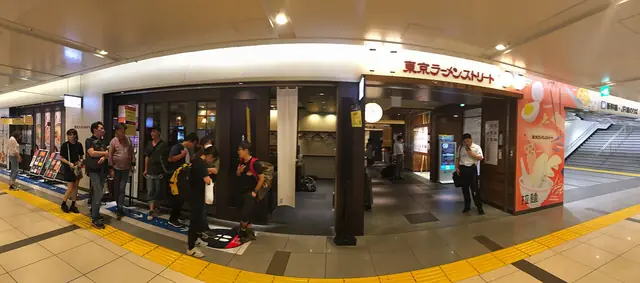 夜の東京ラーメンストリートと店の前に並ぶ人たち