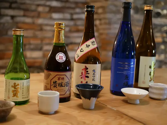 ラベルの異なる日本酒の瓶と小さな杯