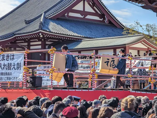 節分に増上寺の特設舞台から豆をまく人たち