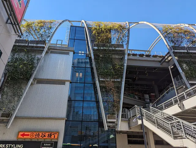明治通りから見たMIYASHITA PARKの鉄骨アーチと緑のテラス