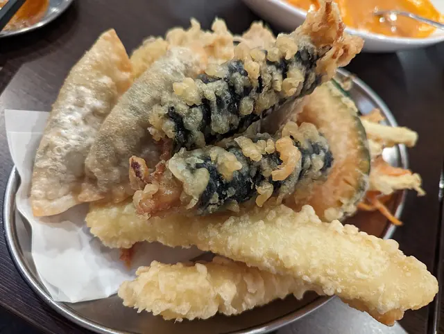 A plate of Korean fried snacks, including seaweed rolls and dumplings, at a restaurant in Shin-Okubo