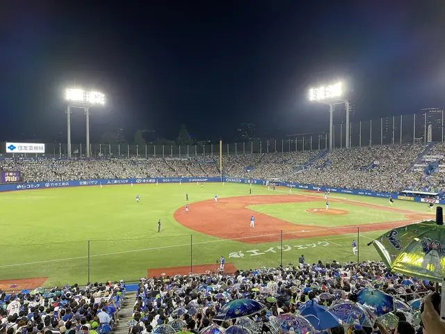神宮球場のナイター。ヤクルトファンが傘を振って応援する