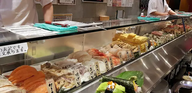 ガラスケースにネタが並ぶ渋谷の立ち食い寿司のカウンター