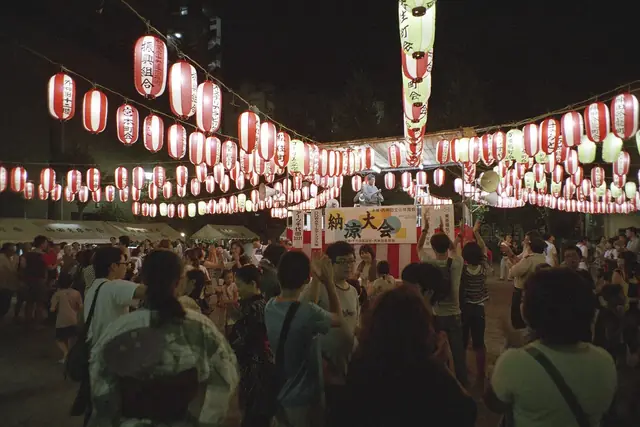 Dancers circle under rows of paper lanterns at a bon odori in Akihabara