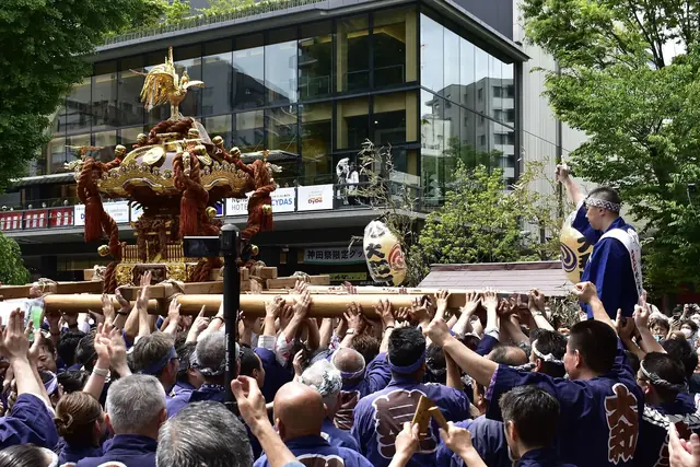 Bearers carry a golden mikoshi into Kanda Myojin for the miyairi during Kanda Matsuri